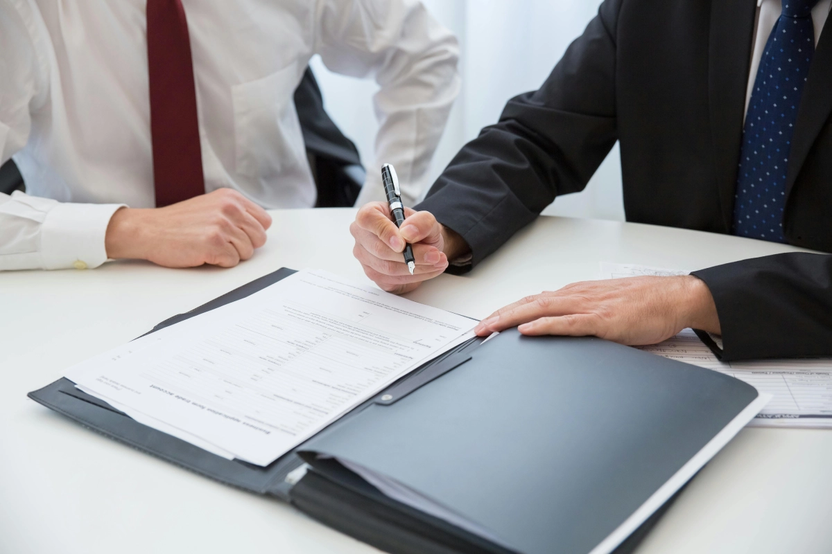 A group of people sitting at a table with papers.